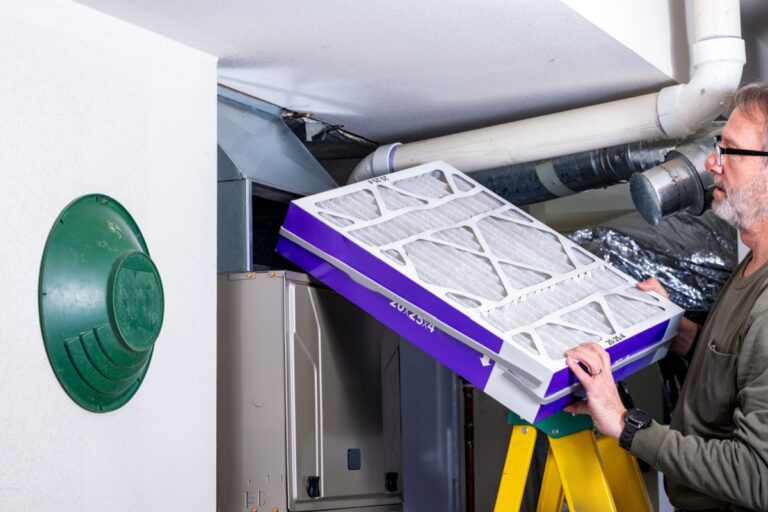 HVAC technician installing a new filter in a furnace unit